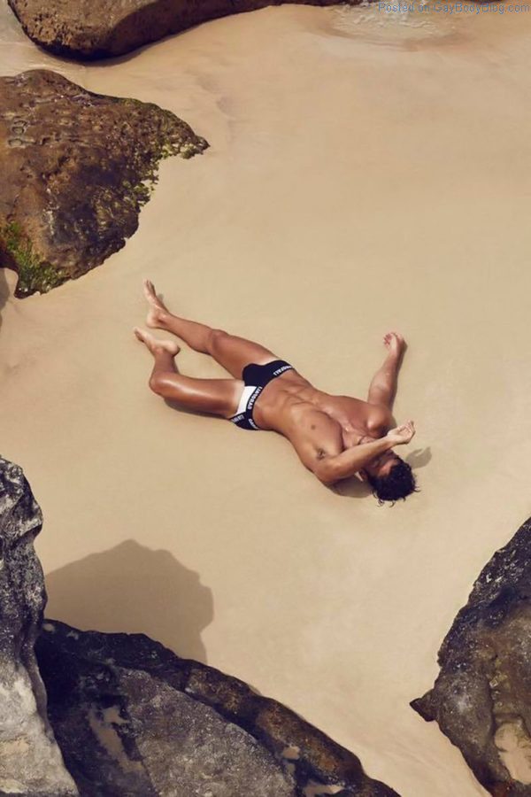 Daniel Garofali laying in the sand with a large Australian jock bulge in his underwear