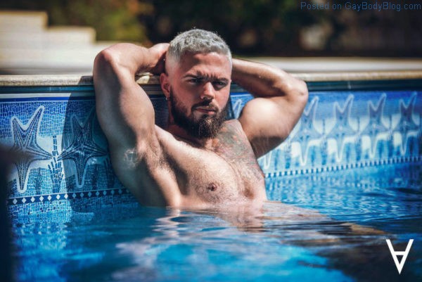 Male model Adriano Cardoso laying in a swimming pool