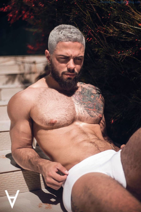 Handsome male model Adriano Cardoso lays in the sun wearing white underwear