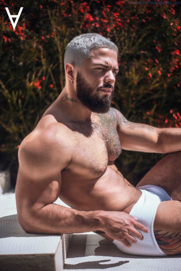 Handsome and bearded male model in white underwear outside