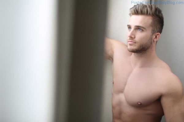 Handsome male model gazing out of a window