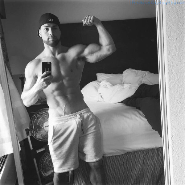 muscle man posing in a black and white selfie with his cock bulge showing in his sweat pants