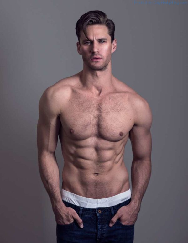 Male model Nicholas Cunningham standing shirltess in jeans