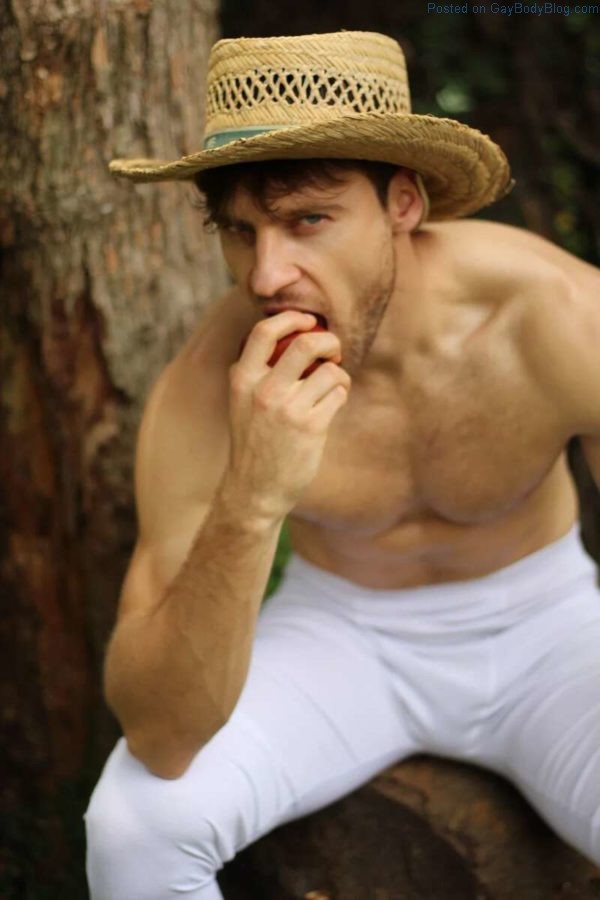 Handsome Male model Vinicius Piccoli eating an apple shirtless