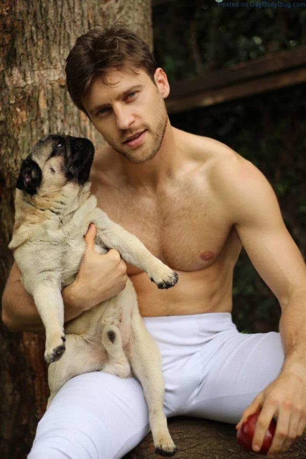 Gorgeous Male model Vinicius Piccoli holding a pug