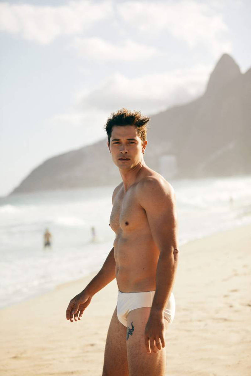 handsome Brazilian model Francisco Lachowski at the beach in swimming trunks