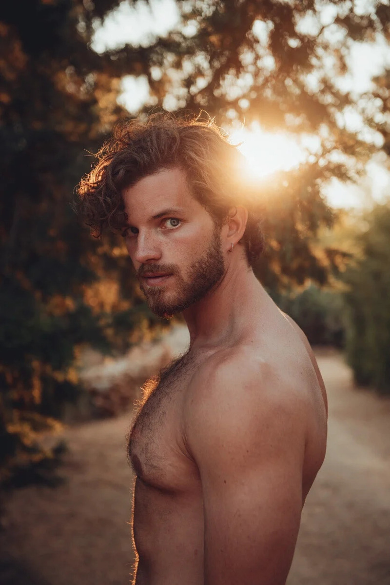 shirtless and handsome male model Emanuele looking into the camera.