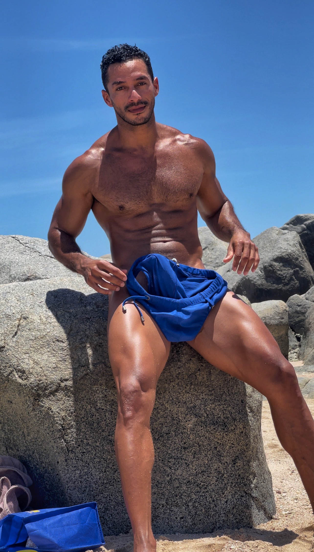 Alexander Ortega Borja teases his big cock behind blue trunks at the beach