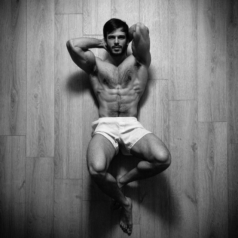 handsome muscular model wearing white boxer shorts laying on the floor